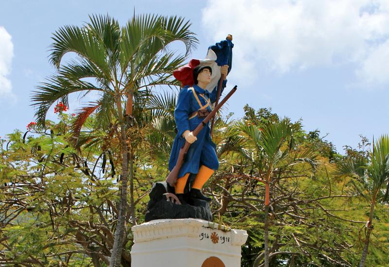 Le traditionnel poilu, capote bleu horizon et bandes molletières, brandissant le drapeau